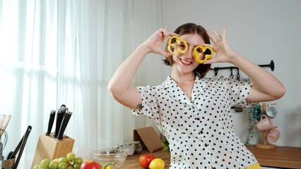 Happy mother chopping at vegetable or making salad and pose at camera. House keeper prepare fresh...