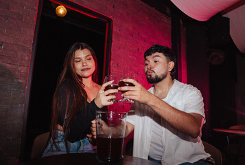 LGBT couple friends sitting and drinking beer in a bar happily