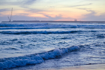 Beautiful sunset over the calm sea with soft pastel colors in the sky and gentle waves on the...