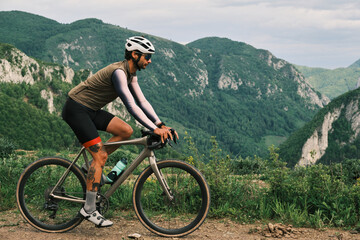 Cyclist on gravel bike enjoying scenic mountain view.  Epic adventure, active lifestyle, freedom...