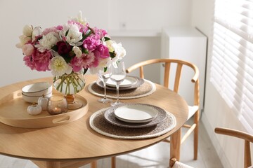 Beautiful table setting with bouquet of peonies in dining room, closeup