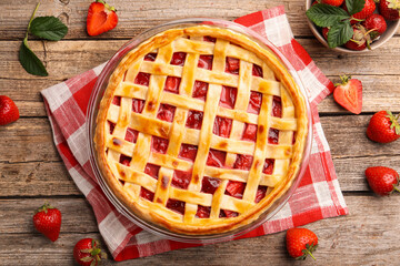 Tasty strawberry pie and berries on wooden table, flat lay