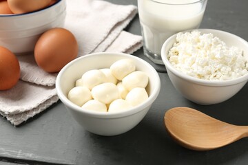 Different dairy products and eggs on grey wooden table, closeup