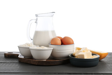 Different dairy products and eggs on grey wooden table against white background