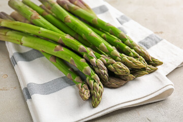 Fresh raw asparagus on light grey table, closeup