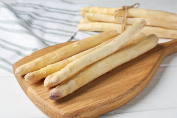 Raw asparagus spears on white wooden table, closeup