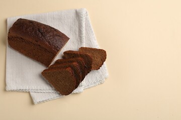 Pieces of fresh rye bread on beige background, top view. Space for text