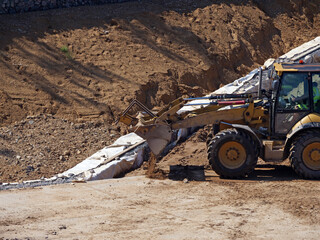 Industrial Machinery: Front Loader Shaping Ground for Civil Engineering Project