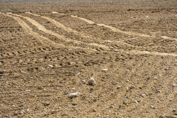 Rows of soil before planting. Drawing of furrows on a plowed field prepared for spring sowing of agricultural crops. View of the land prepared for planting and growing crops.