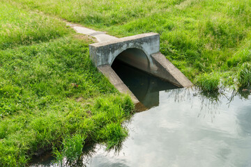 Underground pipes for draining rivers in the city. Discharge of industrial water into a reservoir....