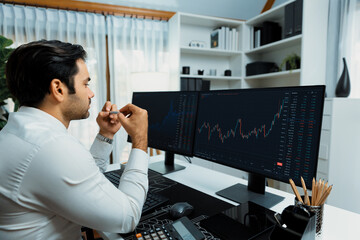 Smart trader businessman analyzing in two dynamic stock exchange investment screen on pc with...