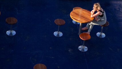 top view of single pensive woman sitting at table