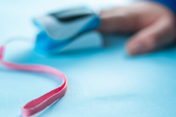 Naklejka premium Detailed image of a medical device placed on a finger to measure health indicators, conveying healthcare technology and monitoring. Focus on foreground with copy space.