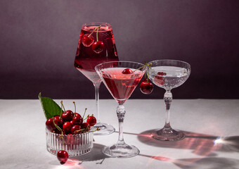 Refreshing cherry cocktails and fresh cherries on white table