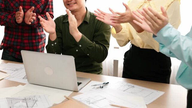 Architect and safety engineer celebrate success design building blueprint project on laptop with architectural document and measurement tool scatter around at modern office. Closeup. Delineation.