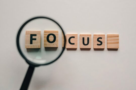 The word focus is made of wooden letters with a magnifying glass. Selective focus.