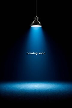 Spotlight shining on dark background with coming soon text.