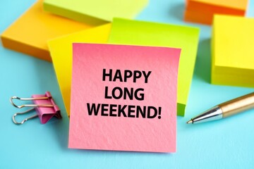 Happy Long Weekend text on notepad, concept blue background.