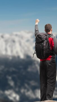 Rear view of couple with backpack standing against winter landscape with snowy mountain ranges