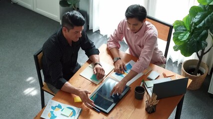 Top view of business team working together to analysis data by using tablet on meeting table. Diverse creative people discussing and brainstorming plan while looking at financial graph. Convocation. - Powered by Adobe