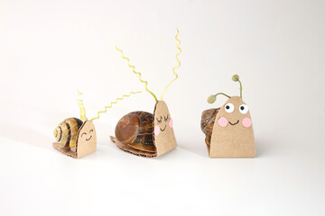 Snails with handmade cardboard costumes as cute characters, crafted for creative use in animation,...