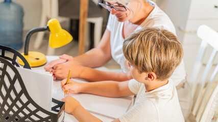 A mother prepares a boy for school and does his homework with him.