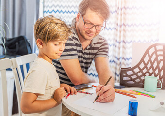 Father and son are doing their homework for school