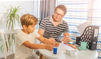 Father and son are doing their homework for school