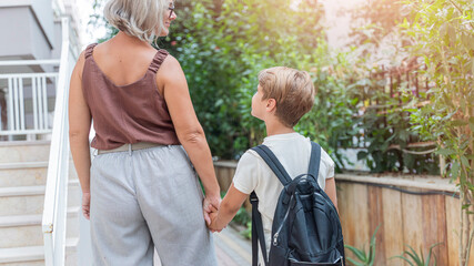 a mother is taking her first-grade son to school