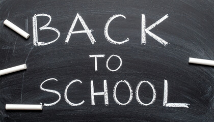 Chalkboard with &ldquo;Back to School&rdquo; Written in White Chalk, Surrounded by Chalk Pieces