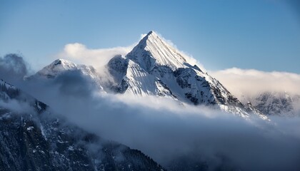 snow capped mountain peak emerging from fog