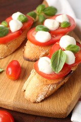 Tasty sandwiches with mozzarella cheese, tomatoes and basil on table, closeup