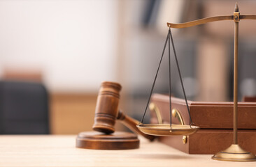 Judge's gavel, scales and document tray on wooden table in office, closeup. Space for text