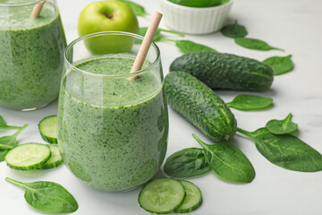 Tasty spinach smoothie and ingredients on white table, closeup