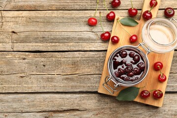 Tasty cherry jam and fresh fruits on wooden table, flat lay. Space for text
