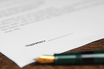 Notary document and fountain pen on wooden table, selective focus
