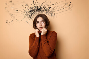 Worried woman on pale brown background. Confused thoughts as doodles coming out of her head....