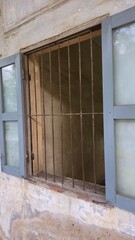 Phnom Penh, Cambodia - 25 June 2025. A barred window with faded shutters at Tuol Sleng Genocide...
