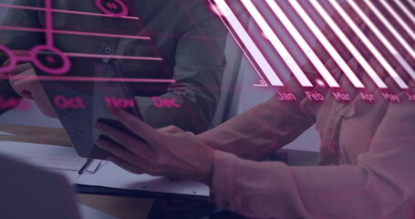 Analyzing colleagues reviewing holographic data overlay on office desk, tablet, paperwork