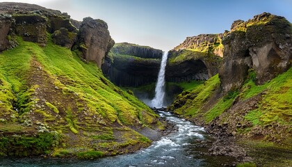 Obraz premium majestic waterfall cascades down rugged cliffs surrounded by vibrant green moss and rocky terrain glymur waterfall canyon in iceland