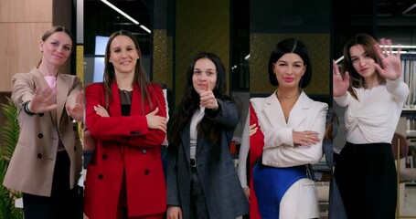 Four businesswomen stand together in office, team unity shown confident poses, team cohesion, team strength evident in professional group diverse women expressing mutual support and alignment.