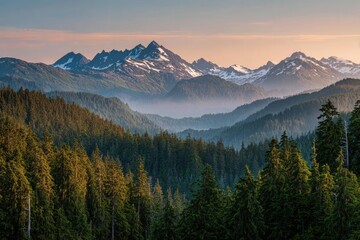 Obraz premium Serene sunset view over a vast, layered landscape of evergreen forests and snow-capped mountains. The mountains are bathed in soft, warm light