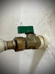 old metal water tap in a poor toilet looks dirty and rusty