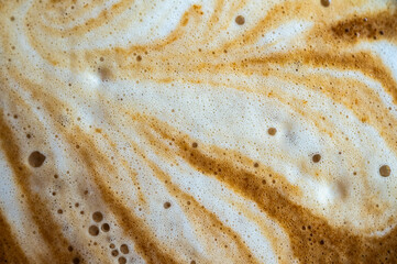 Full frame shot of the surface of hot latte coffee. A latte is a coffee drink made with espresso and steamed milk.