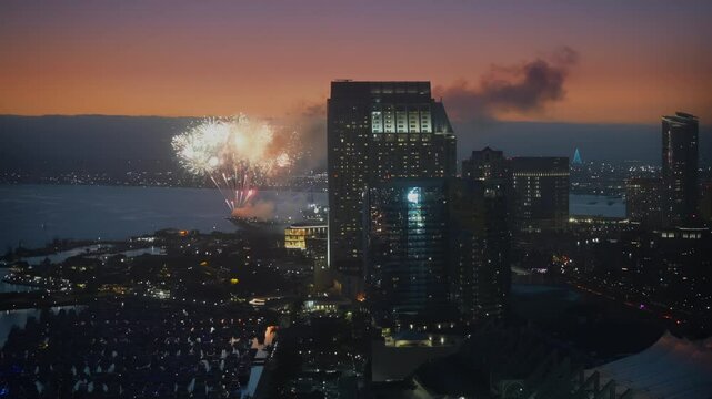 Rooftop view of San Diego downtown summer night fireworks over the Bayfront area with dramatic sunset sky