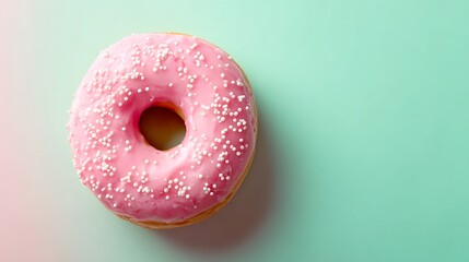 Close up of a single pink frosted donut with white sprinkles on a pastel background