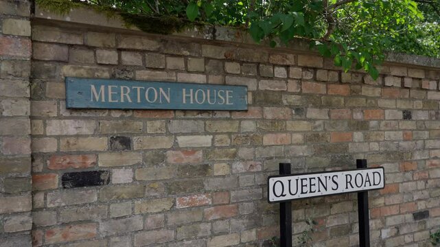 Queen s Road street sign and Merton House sign on a brick wall in Cambridge, UK