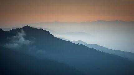Obraz premium Misty mountain ranges fade into sunrise