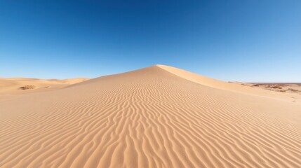 Stunning desert landscape featuring a large sand dune under a clear blue sky, showcasing natural beauty and tranquility.