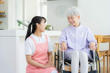 リビングで介護をする若い女性介護士